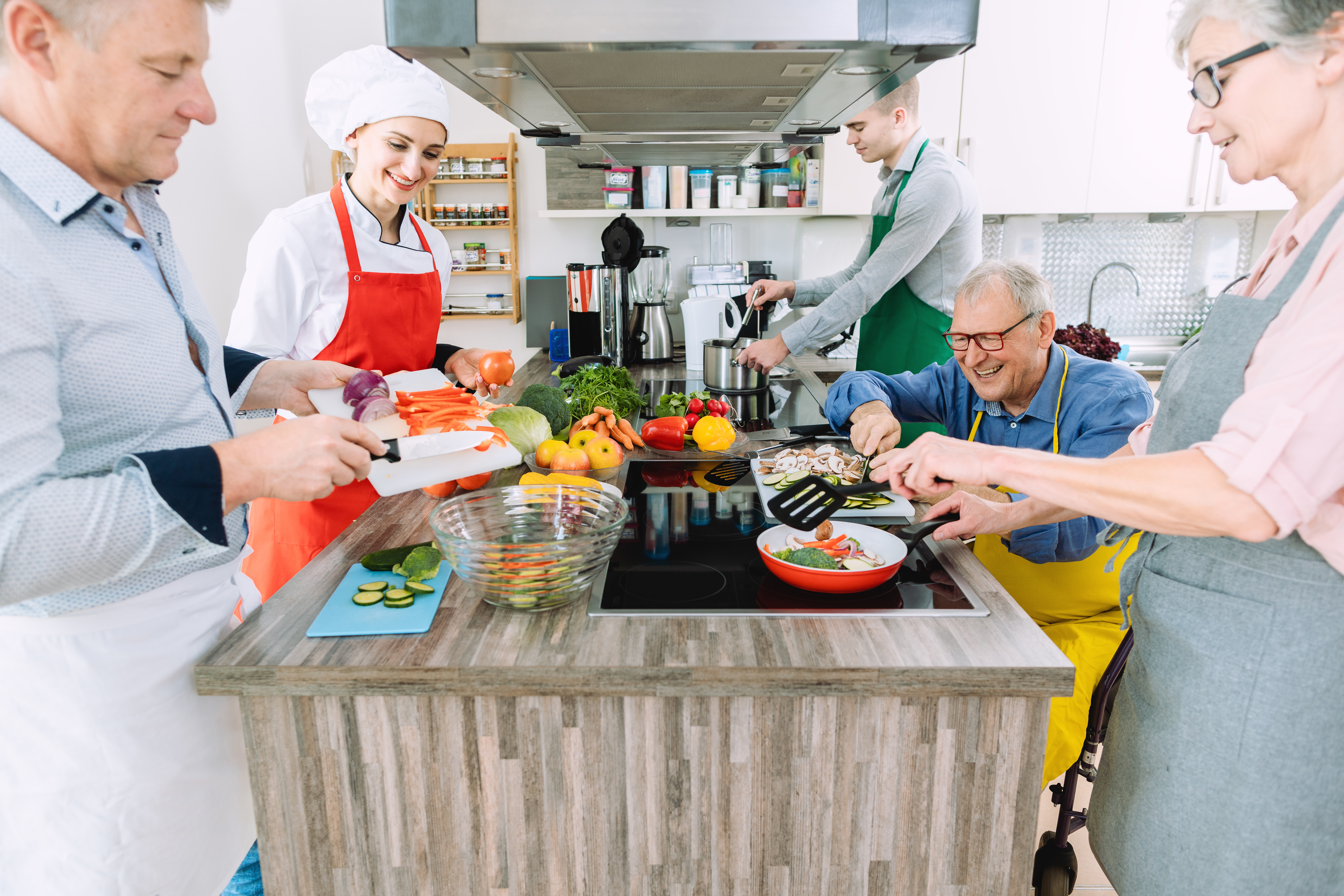En Gruppe Mennesker, Der Laver Mad Ved Et Bord
