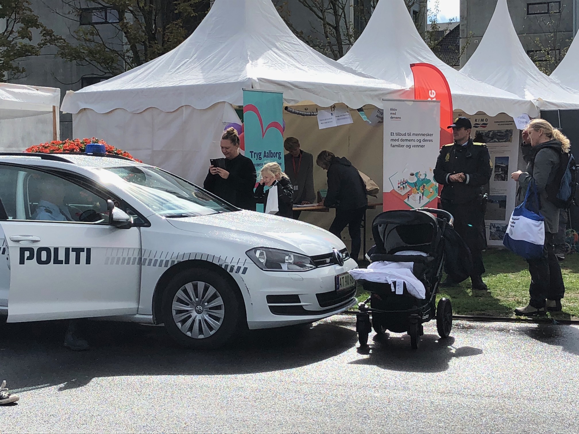 Politibil, der holder foran nogle hvide telte